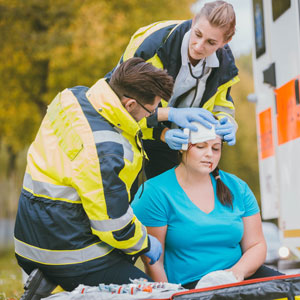 Woman receiving medical treatment from ambulance crew after personal injury - The Yolles Legal Group