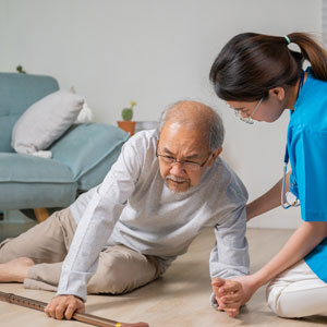 Nurse assisting elderly man to stand up after Slip And Falls - The Yolles Legal Group